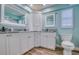 Bright bathroom with dual sinks, marble countertops, custom cabinetry, and modern fixtures at 2773 Seabreeze S Dr, Gulfport, FL 33707