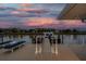 Well-lit boat dock and waterfront area under a beautiful sunset sky, ideal for relaxation and entertainment at 2773 Seabreeze S Dr, Gulfport, FL 33707