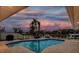 Backyard pool area with in-ground pool, view of sunset, lounge furniture, and boat dock at 2773 Seabreeze S Dr, Gulfport, FL 33707