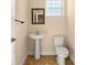 Small bathroom with pedestal sink, toilet, and tiled floor at 562 Rivercrest Ln, Tarpon Springs, FL 34689