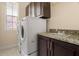 Bright laundry room, featuring washer, dryer, cabinets, and granite countertop at 562 Rivercrest Ln, Tarpon Springs, FL 34689