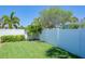 Private backyard with grassy area, white vinyl fence, and lush landscaping at 8651 Gulf Blvd, St Pete Beach, FL 33706