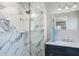 Modern bathroom featuring a glass shower with blue-veined marble tile and vanity with elegant marble countertop at 8651 Gulf Blvd, St Pete Beach, FL 33706