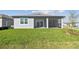 The house has a large green lawn and sliding glass doors leading out onto the screen patio at 11207 Shoreline Trl, Parrish, FL 34219