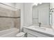 Bathroom with a white vanity, white countertop, and beige tile shower at 11207 Shoreline Trl, Parrish, FL 34219