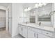 Elegant bathroom featuring double sink vanity with quartz countertop, large mirror, and tiled shower at 11207 Shoreline Trl, Parrish, FL 34219