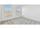 Bright bedroom with neutral carpet flooring and two sunny windows with outside views at 11207 Shoreline Trl, Parrish, FL 34219