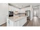 Modern kitchen showcasing white cabinetry, stainless steel appliances, and an eat-in island at 11207 Shoreline Trl, Parrish, FL 34219