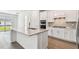 A gourmet kitchen features white cabinets, stone countertops, and stainless steel appliances at 11207 Shoreline Trl, Parrish, FL 34219