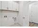 Functional laundry room with storage cabinets, tile flooring, and washer/dryer hookups at 11207 Shoreline Trl, Parrish, FL 34219