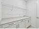 Clean laundry room featuring white cabinets, a white counter, and a wire shelf at 11207 Shoreline Trl, Parrish, FL 34219