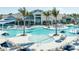 Luxury resort-style pool with surrounding lounge chairs and palm trees at 11207 Shoreline Trl, Parrish, FL 34219
