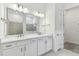 Bathroom featuring double sinks, white cabinets, and a shower with decorative tile at 11517 Waterway Dr, Parrish, FL 34219