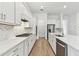 Bright kitchen featuring white cabinetry, quartz countertops, stainless steel appliances, and wood flooring at 11517 Waterway Dr, Parrish, FL 34219