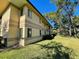 Building exterior showcasing light beige walls, dark windows, and green lawn at 2671 Sabal Springs Cir # 102, Clearwater, FL 33761