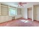 Bedroom with built-in shelving, desk, and pink carpeting at 36919 Chancey Rd, Zephyrhills, FL 33541