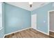 Bedroom with light blue walls, wood-look floors, and a window at 5938 Sweet Birch Dr, Riverview, FL 33578