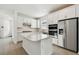 Modern kitchen with white cabinetry, stainless steel appliances, and a large center island at 9450 Shorebird Ct, Parrish, FL 34219