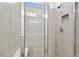Modern shower with neutral tile, glass doors, and built-in niche at 9450 Shorebird Ct, Parrish, FL 34219