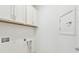 Laundry room features white cabinets and hookups, white wall, and door to the side at 9454 Shorebird Ct, Parrish, FL 34219