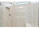 Tiled shower stall with a built-in seat and recessed niche for toiletries at 9454 Shorebird Ct, Parrish, FL 34219