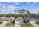 An aerial view of several modern homes with well-manicured lawns and tree lined street at 9462 Shorebird Ct, Parrish, FL 34219