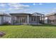 A home's backyard features a screened-in lanai with a view of a lush green lawn at 9462 Shorebird Ct, Parrish, FL 34219