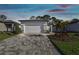 Charming home features a patterned driveway, two-car garage, and nicely landscaped front yard at 9462 Shorebird Ct, Parrish, FL 34219