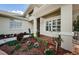 House entrance with a tiled patio, landscaping, and white shutters at 1100 Trafalgar Dr, New Port Richey, FL 34655