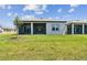 Backyard features a lush lawn, covered patio, and ample space for outdoor living and entertaining at 11208 Shoreline Trl, Parrish, FL 34219