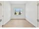 Bright, empty bedroom with wood floors, large window, and neutral walls at 11208 Shoreline Trl, Parrish, FL 34219