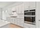 Gourmet kitchen with stainless steel appliances, white cabinets, and modern backsplash at 11208 Shoreline Trl, Parrish, FL 34219