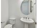 Bathroom featuring pedestal sink, toilet, and a round mirror at 11477 Waterway Dr, Parrish, FL 34219