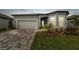 Charming home exterior featuring a two-car garage, beautiful landscaping, and a well-manicured lawn at 11477 Waterway Dr, Parrish, FL 34219