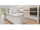 Bright kitchen showcasing a large island, modern appliances, white cabinets, and wood-look flooring at 11477 Waterway Dr, Parrish, FL 34219