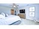 Bright bedroom featuring soft carpet, large windows, and a dresser with a television at 12735 Bergstrom Bay Dr, Riverview, FL 33579