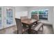 Dining room features a wood table with four chairs and bench seating, hardwood floors and access to backyard at 12905 N Oregon Ave, Tampa, FL 33612