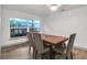 Bright dining room with wood table and four chairs, hardwood floors, and large window at 12905 N Oregon Ave, Tampa, FL 33612