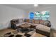 Bright living room featuring an L-shaped sofa and large windows at 12905 N Oregon Ave, Tampa, FL 33612