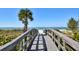 Wooden boardwalk leads to a pristine beach with clear water at 14880 Shipwatch Trce # 1915, Largo, FL 33774
