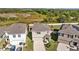 Three-house aerial view showing two-story homes with attached garages and landscaping at 16565 Mosaic Oar Dr, Wimauma, FL 33598