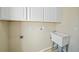 Laundry room with white cabinets and utility sink at 3405 Loggerhead Way, Wesley Chapel, FL 33544