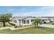 White single-wide manufactured home with palm trees and landscaping at 37652 New Horizons Blvd, Zephyrhills, FL 33541