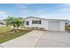 White manufactured home with garage and landscaping at 37652 New Horizons Blvd, Zephyrhills, FL 33541