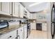 White kitchen cabinets, granite countertops, and stainless steel appliances at 37652 New Horizons Blvd, Zephyrhills, FL 33541
