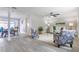 Bright living room featuring grey laminate flooring, neutral walls, ceiling fan, and comfortable furnishings at 3848 Stratfield Dr, New Port Richey, FL 34652