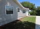 Side view of house showcasing gray siding and a grassy yard at 4201 Dr Martin Luther King Jr N St, St Petersburg, FL 33703