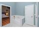 Bathroom with soaking tub, view of bedroom, and separate shower at 5403 Golddust Rd, Spring Hill, FL 34609