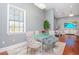 Elegant dining room with glass table and seating for four, overlooking the living area at 5403 Golddust Rd, Spring Hill, FL 34609