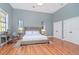 Luxurious main bedroom with a king-size bed, hardwood floors, and plenty of natural light at 5403 Golddust Rd, Spring Hill, FL 34609